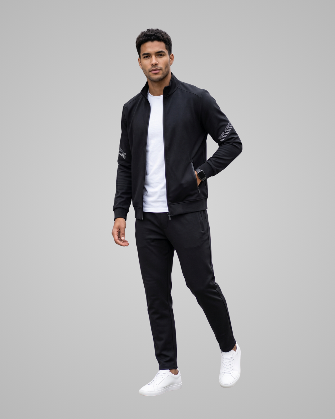 Man wearing a black tracksuit on a gray background