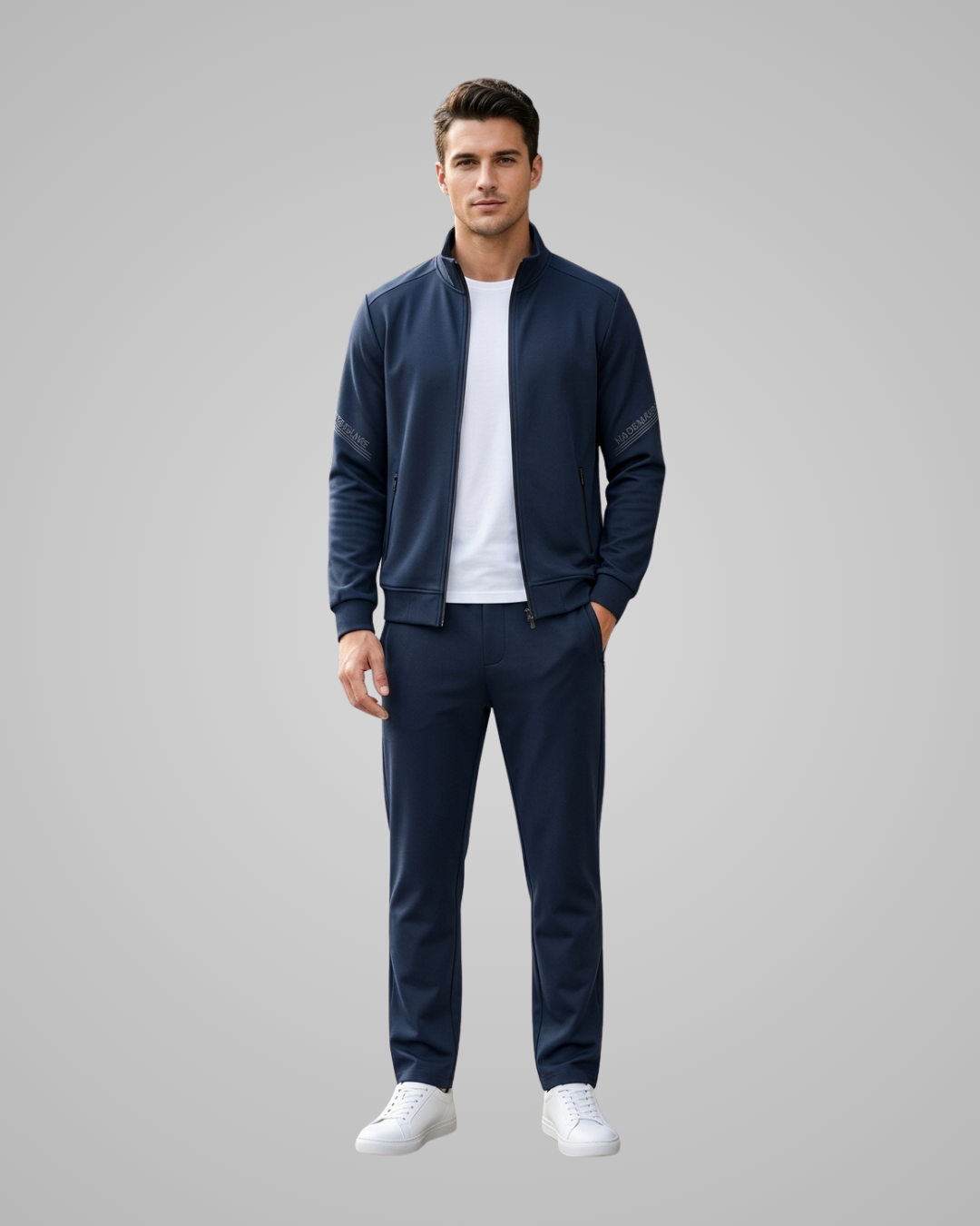 Man wearing a dark blue tracksuit on a gray background