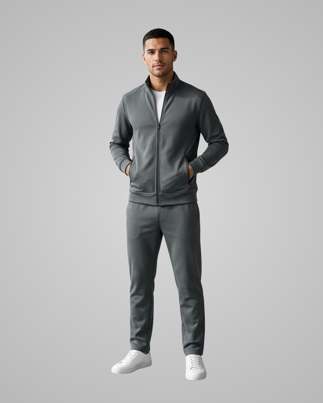 Man wearing a gray tracksuit on a gray background