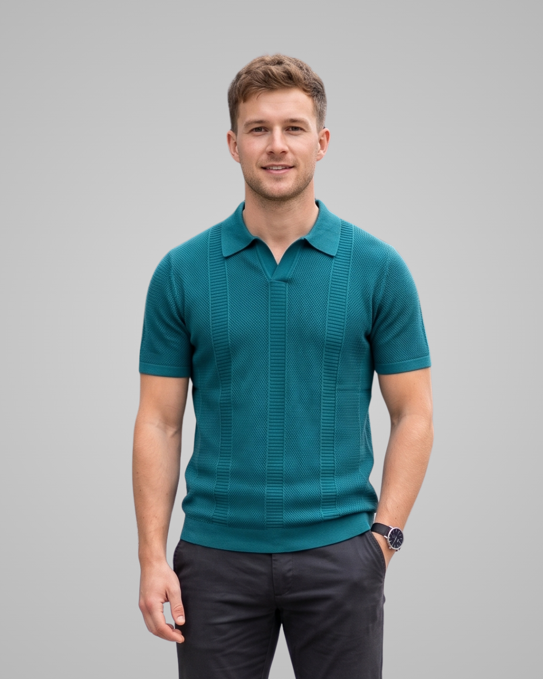 Man wearing a teal polo shirt against a gray background