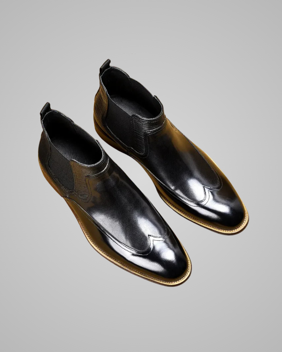 Black leather shoes worn with gray pants on a light gray background