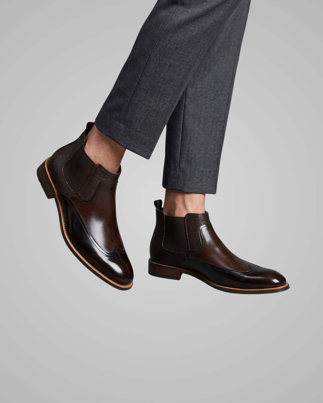 Pair of brown leather boots on a gray background
