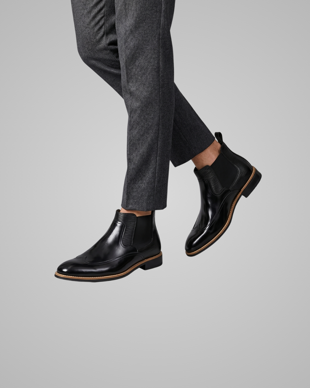 Black leather shoes worn with gray pants on a light gray background