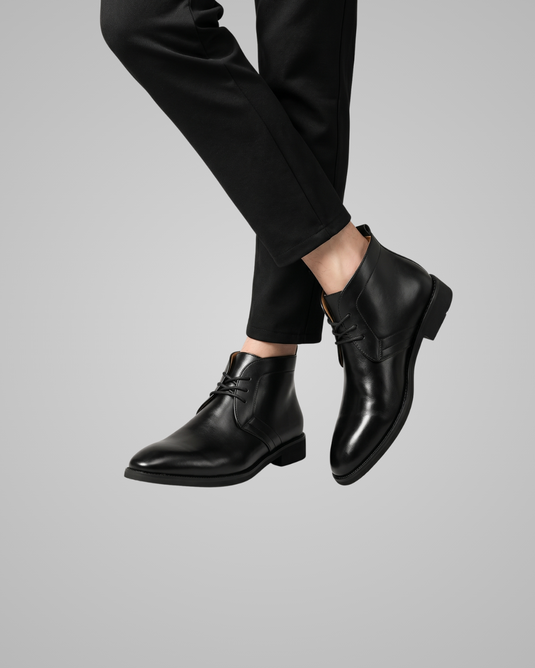 Black leather chukka boot on a gray background