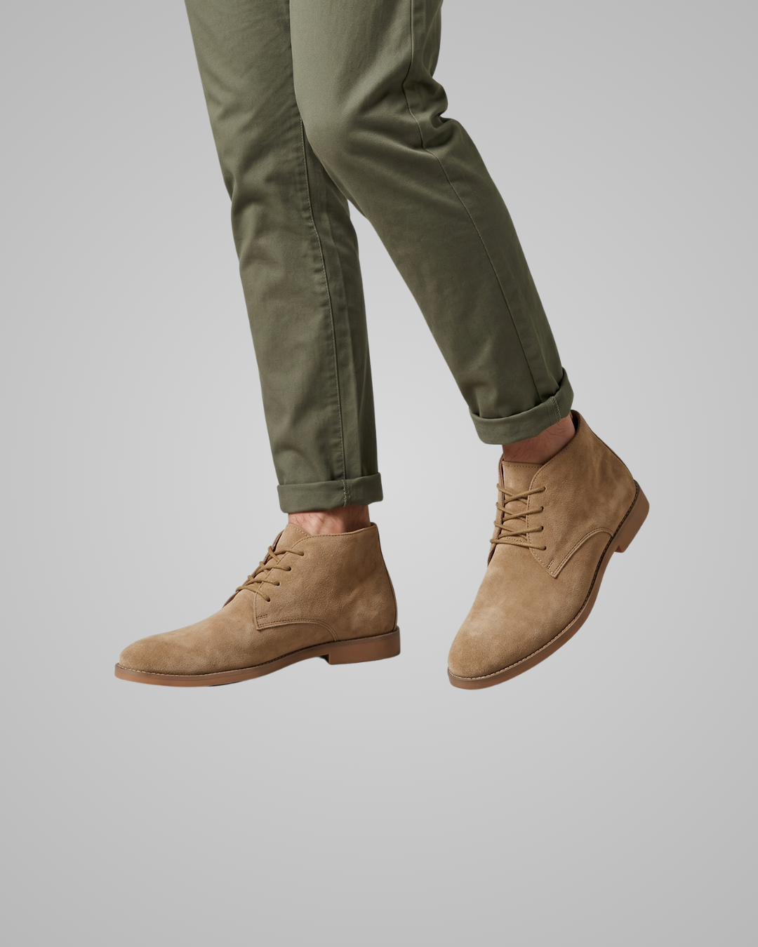Khaki dress shoes worn with gray pants on a light gray background
