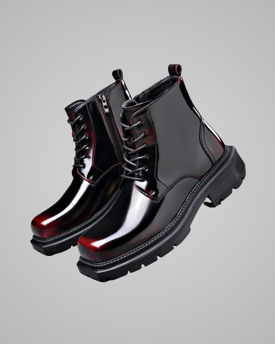 Shiny black boots with red soles on a gray background
