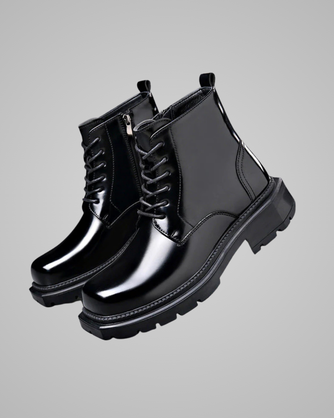 Pair of black glossy boots on a gray background