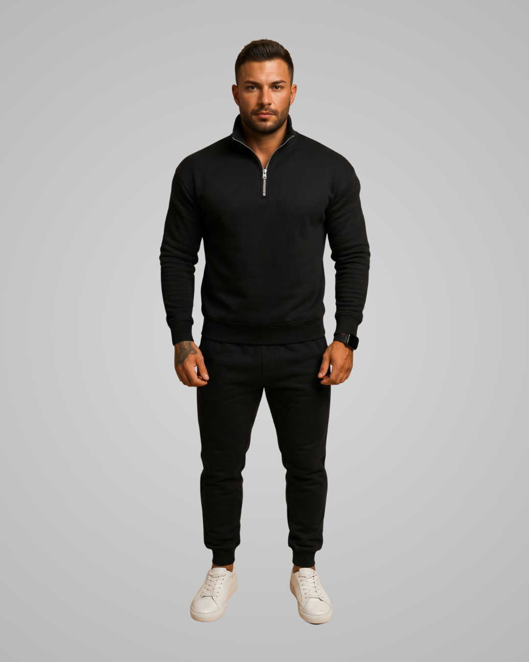 Man wearing a black tracksuit on a gray background
