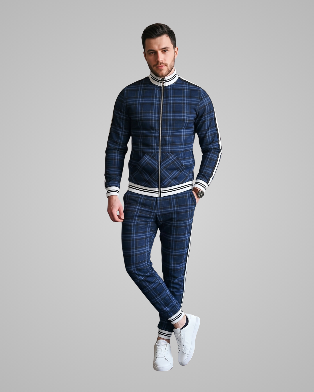 Man wearing a blue plaid tracksuit with white accents on a gray background