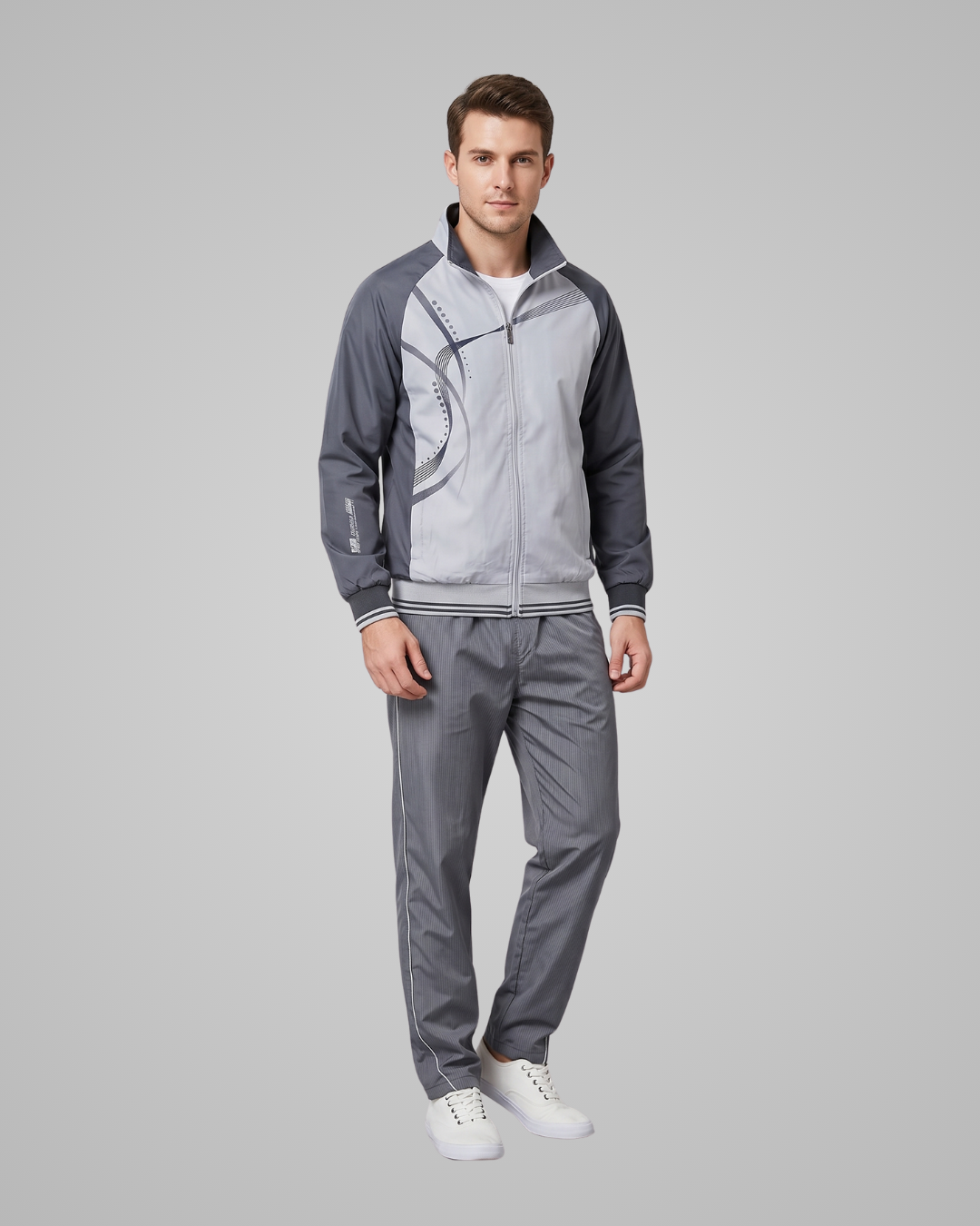 Man wearing a gray tracksuit on a light gray background