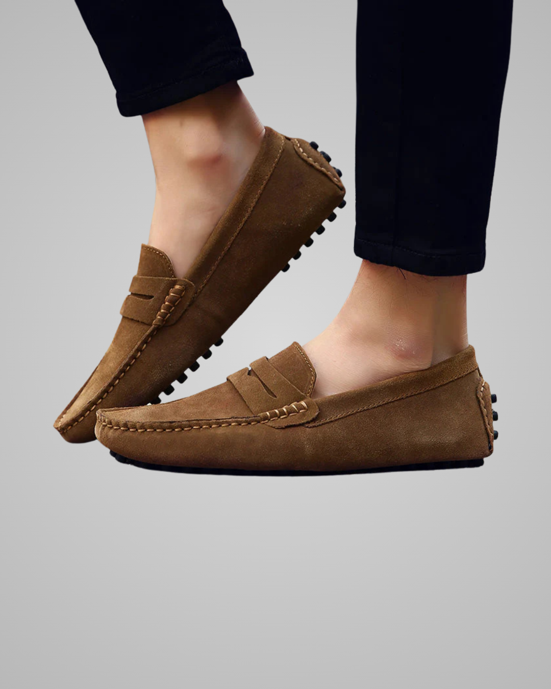 Brown loafers worn by a person on a gray background