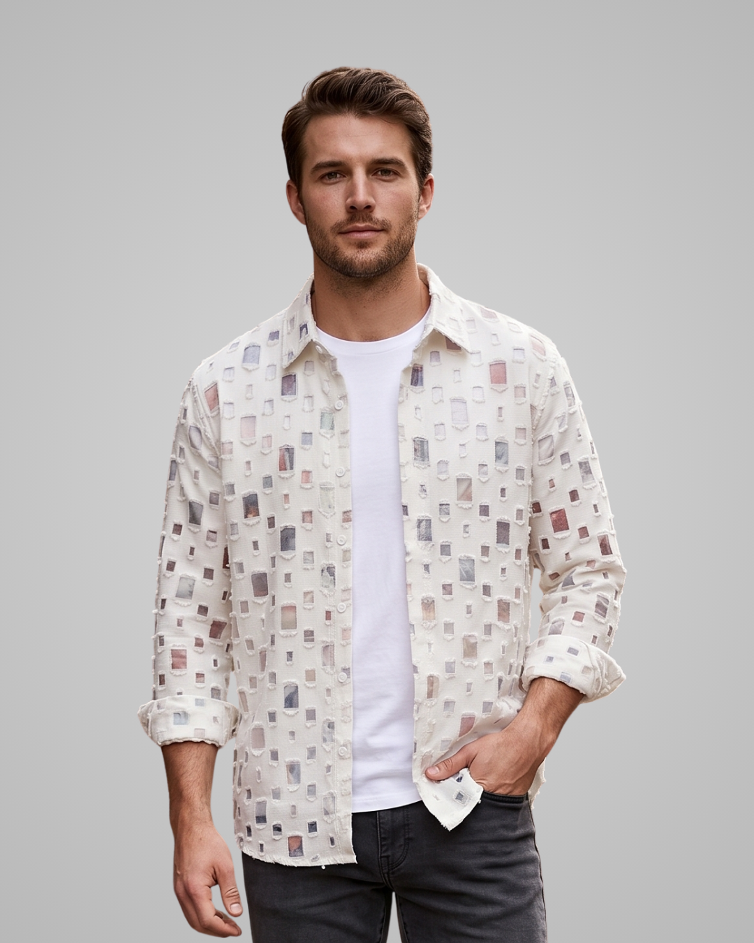 Man wearing a patterned shirt over a white t-shirt on a gray background