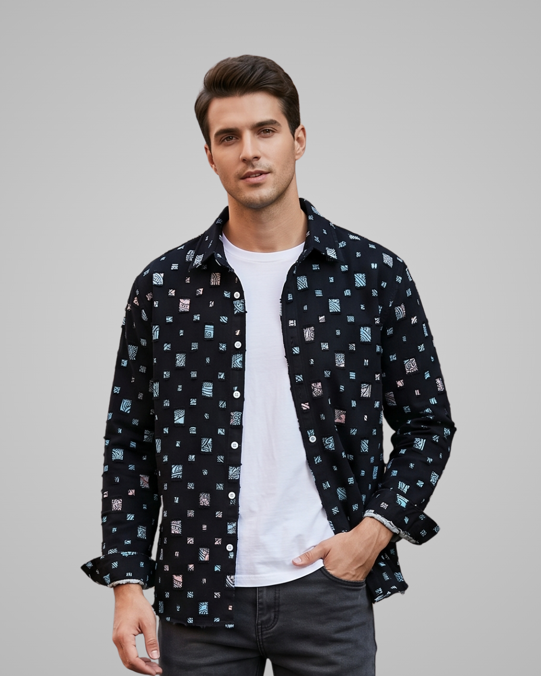Man wearing a patterned shirt over a white t-shirt on a gray background