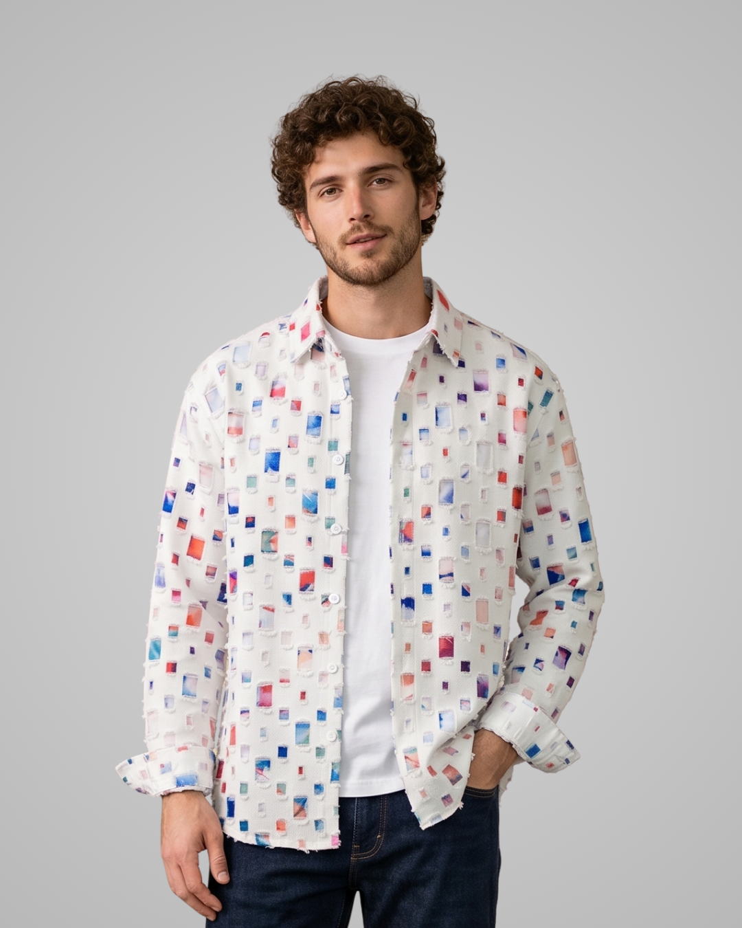 Man wearing a colorful patterned shirt over a white t-shirt on a gray background