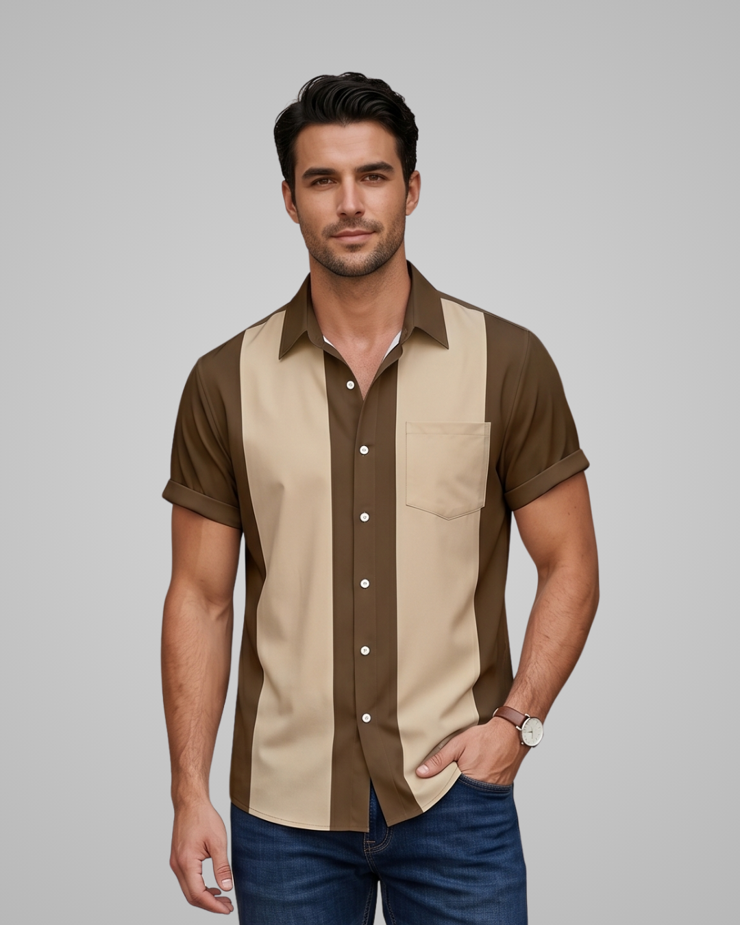 Man wearing a brown and beige striped shirt with blue jeans on a gray background
