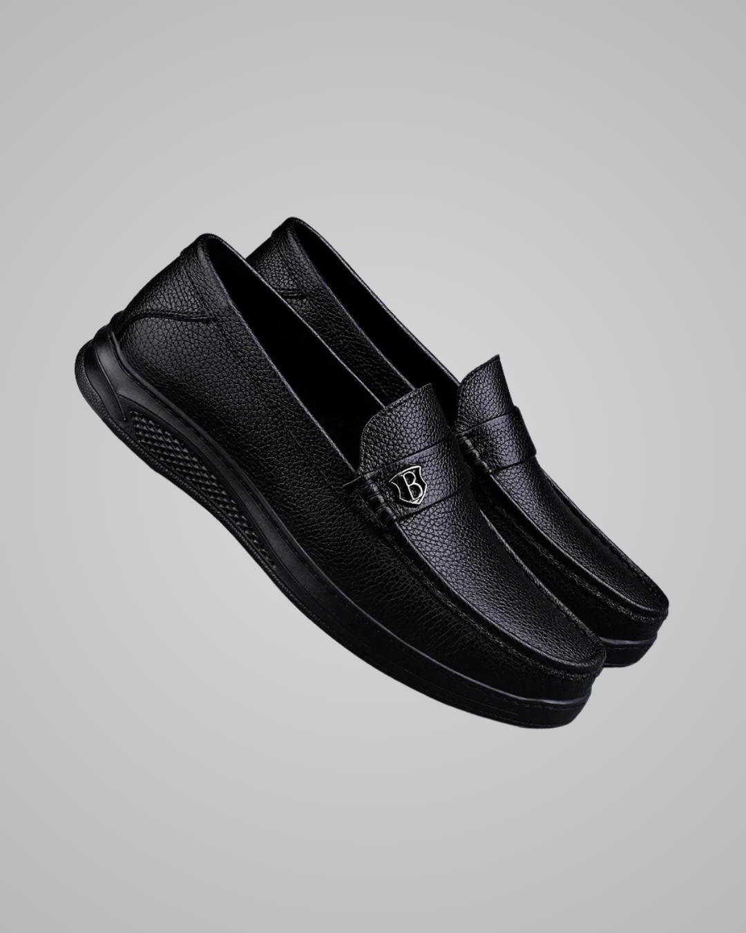 Black slip-on shoes on a gray background