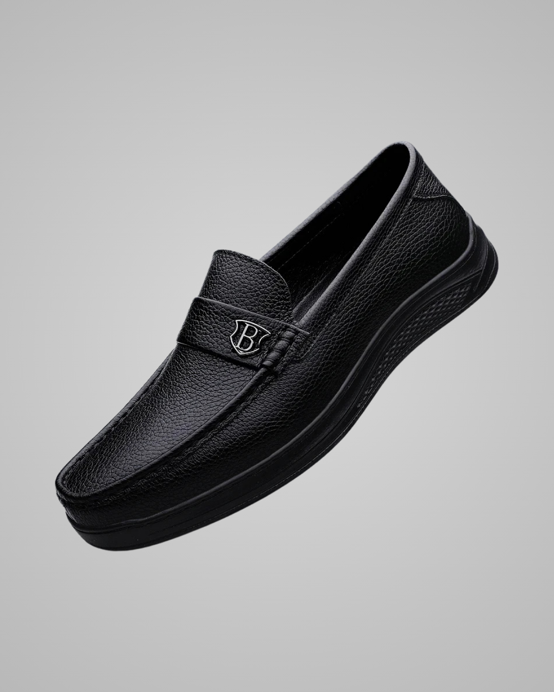 Black leather loafer shoe on a gray background