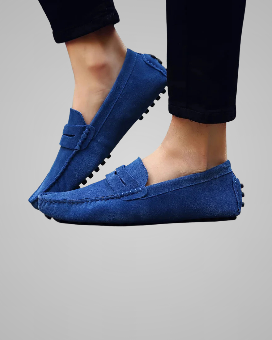 Blue loafers worn by a person on a gray background