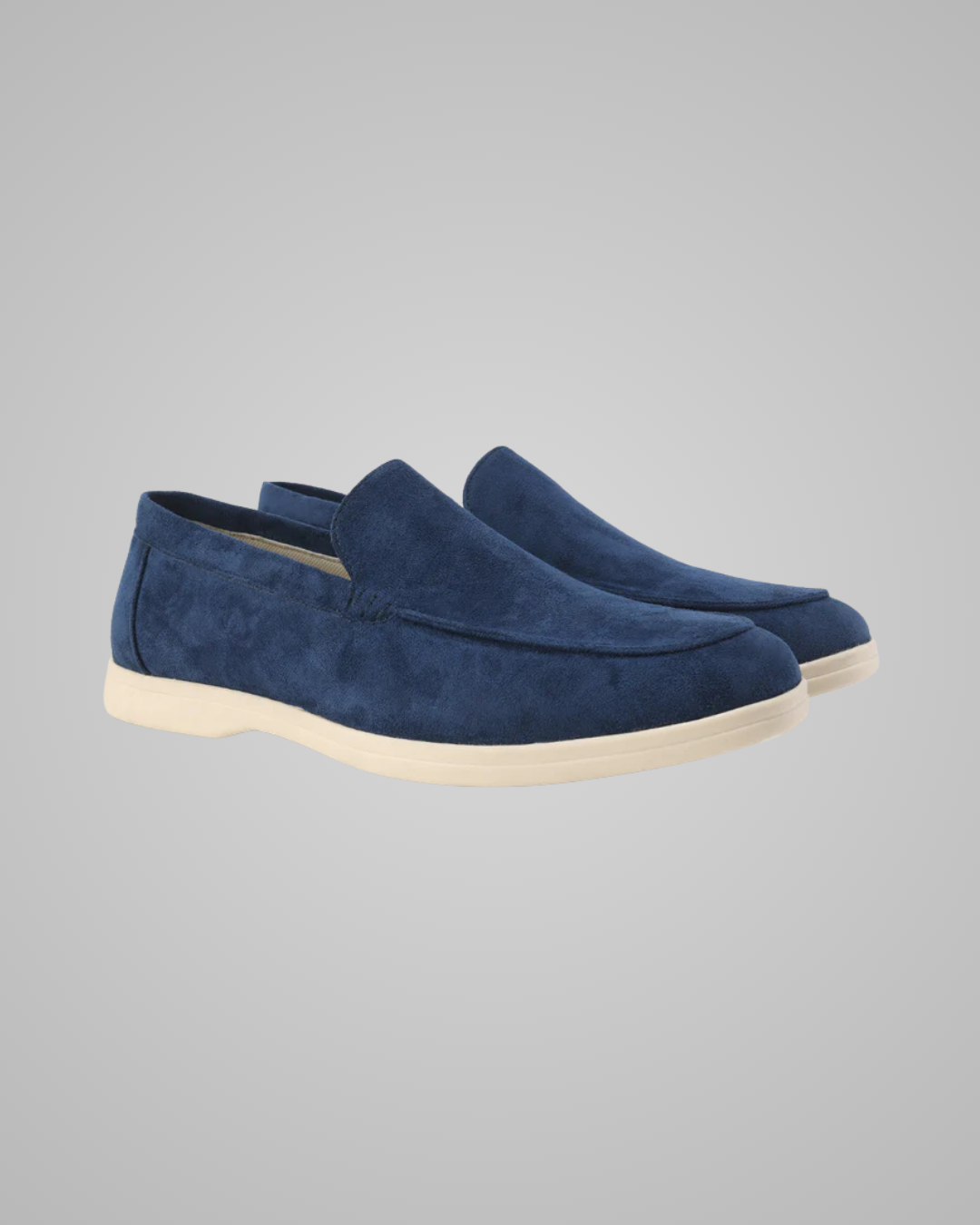 Pair of blue suede loafers on a gray background