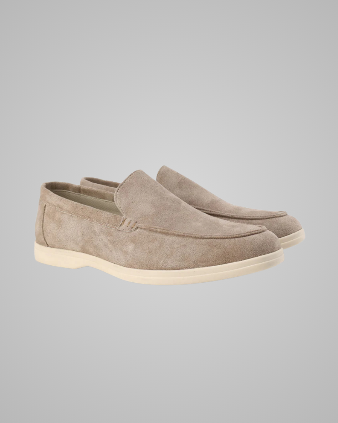 Pair of beige suede loafers on a gray background