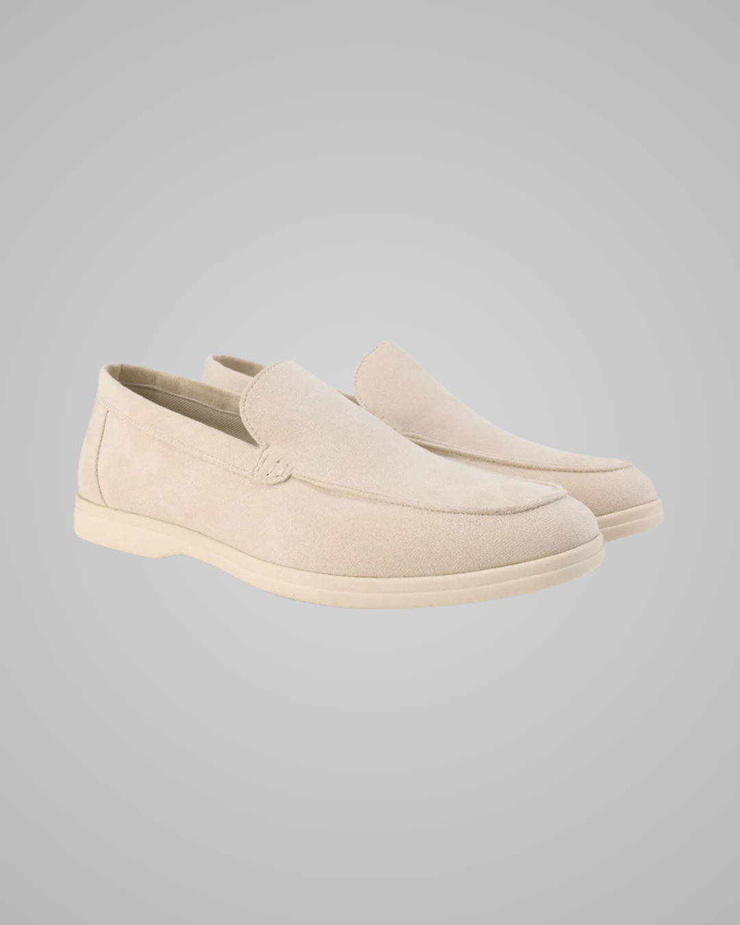 Pair of beige loafers on a light gray background