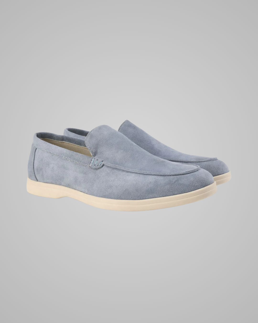 Pair of grey blue suede loafers on a gray background
