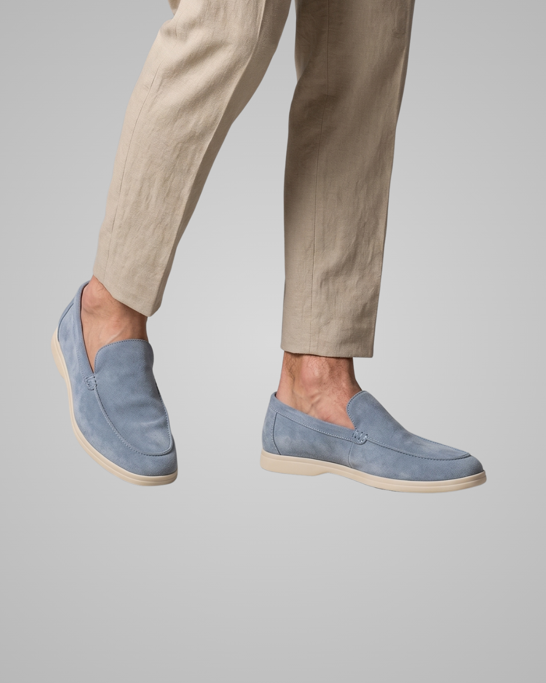 Blue loafers worn with beige pants on a gray background