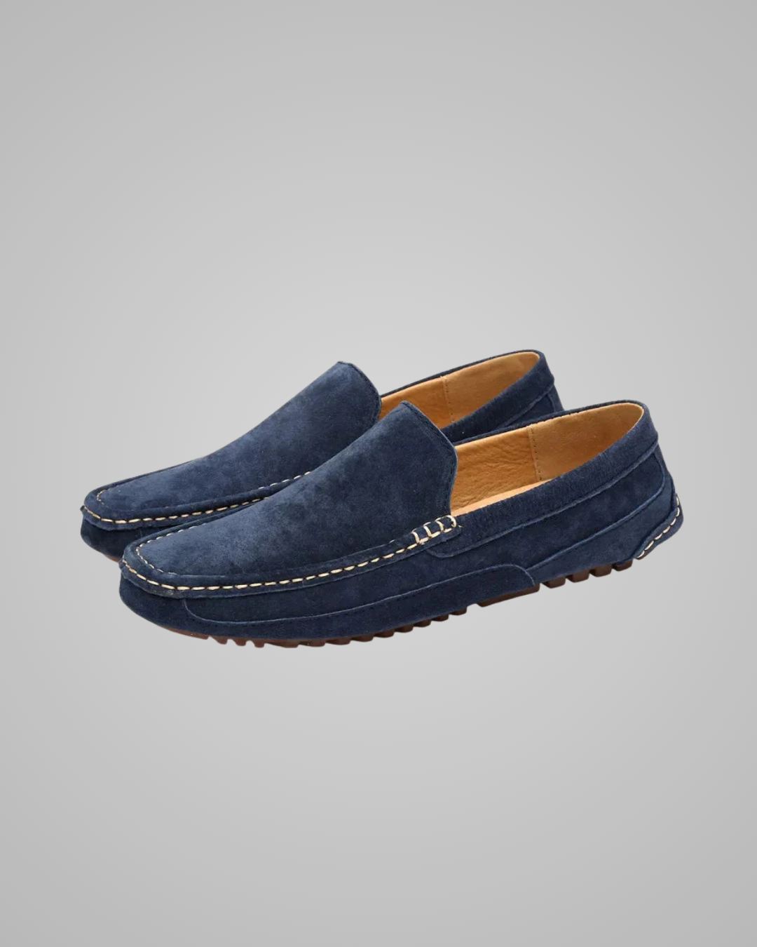 Pair of blue suede loafers on a gray background