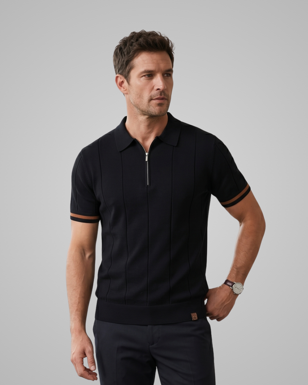 Man wearing a black polo shirt with a zipper on a gray background