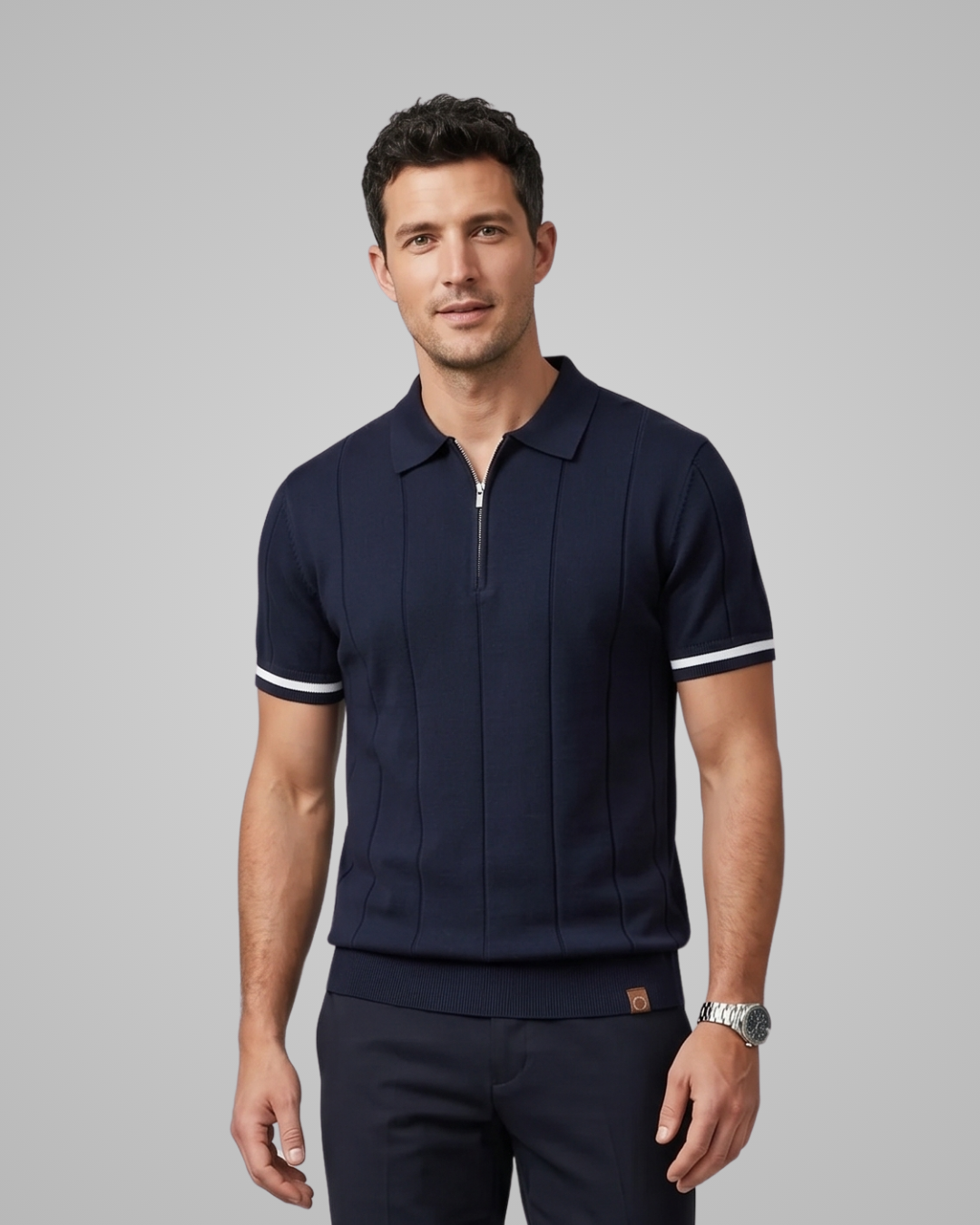 Man wearing a navy blue polo shirt with white trim on a gray background