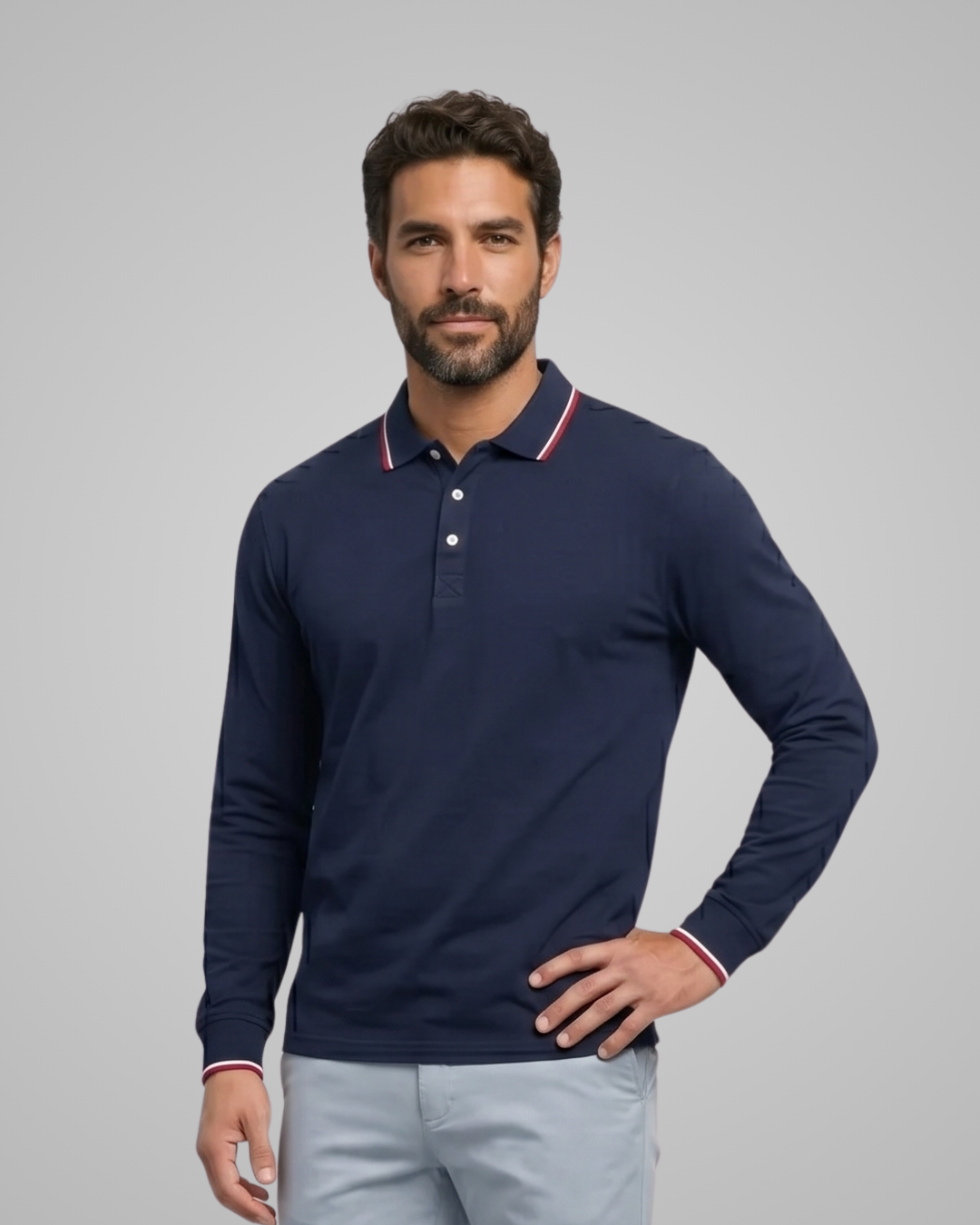 Man wearing a navy long-sleeve polo shirt with white buttons on a gray background