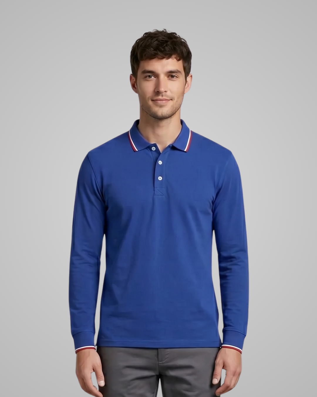 Man wearing a blue long-sleeve polo shirt with white buttons on a gray background