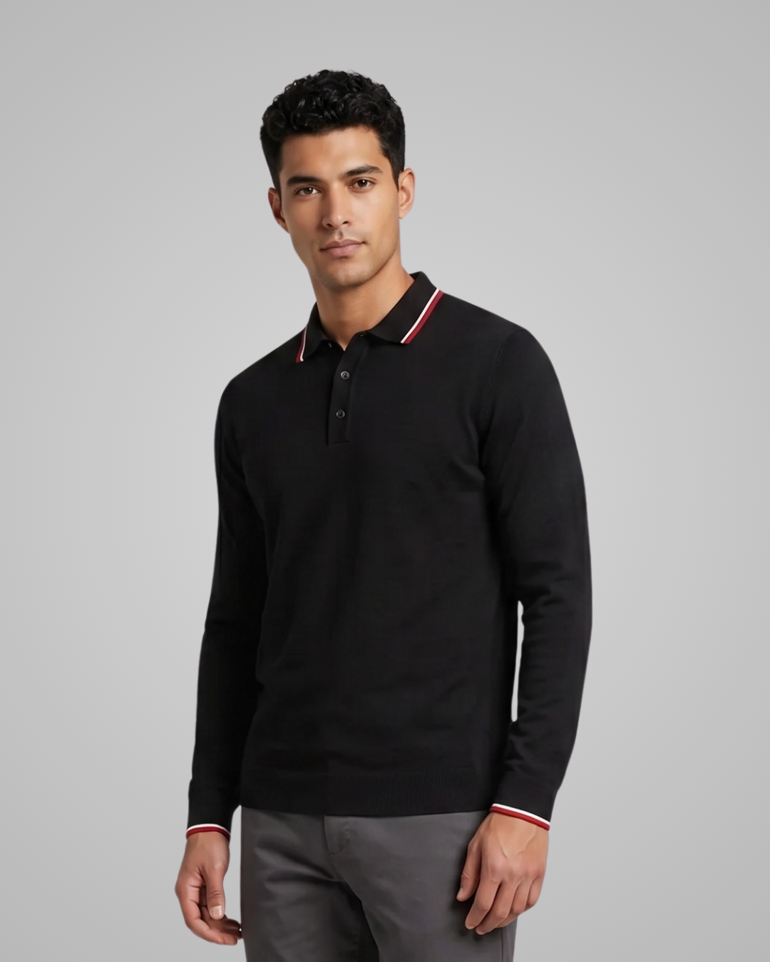 Man wearing a black long-sleeve polo shirt with red and white trim on a gray background