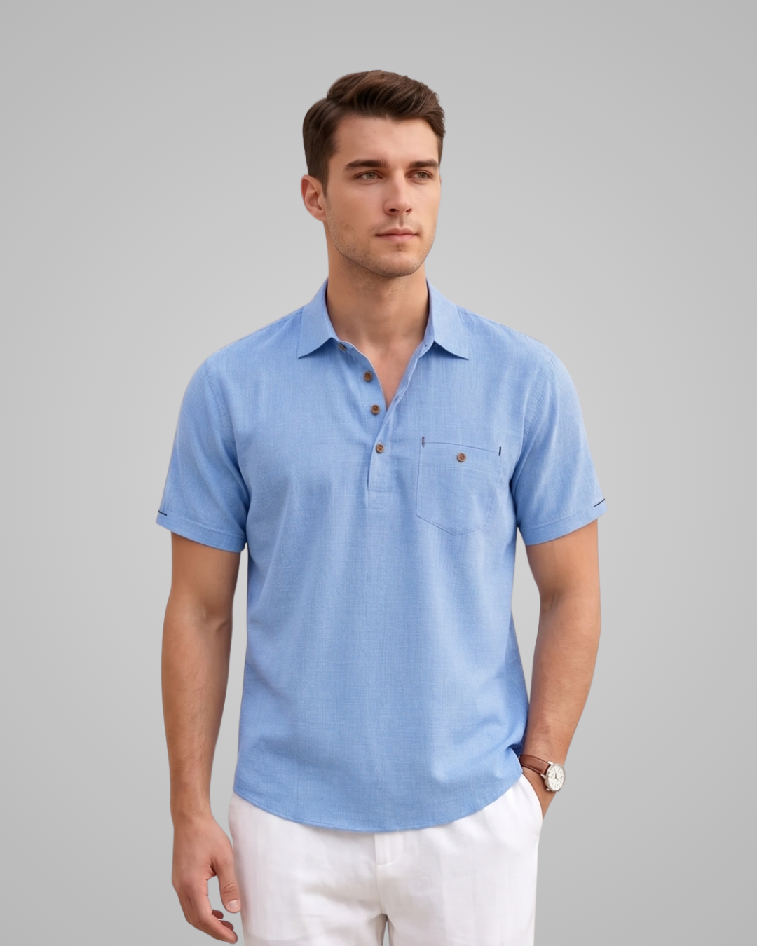 Man wearing a light blue polo shirt against a gray background