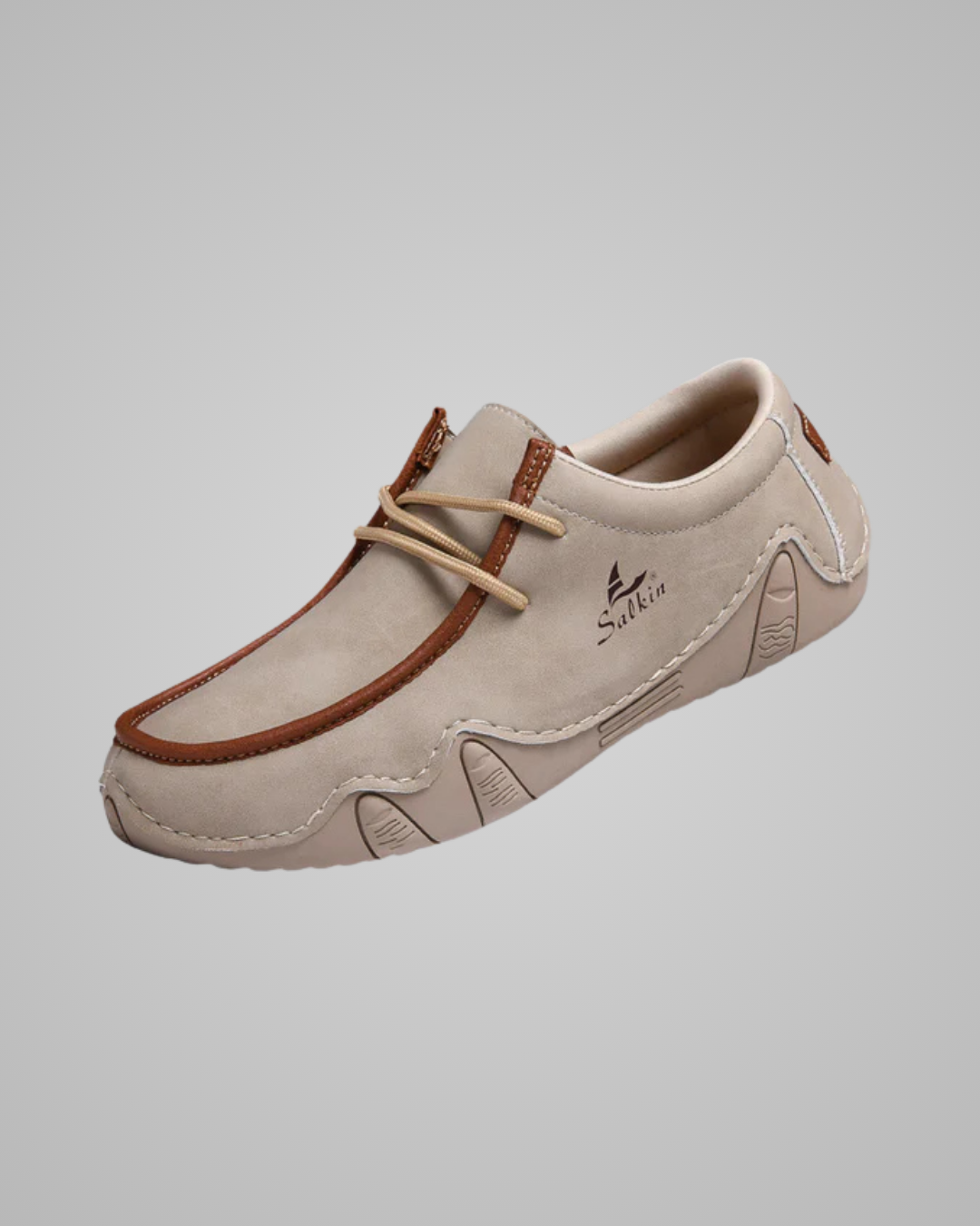 Beige loafer shoe with brown accents on a gray background