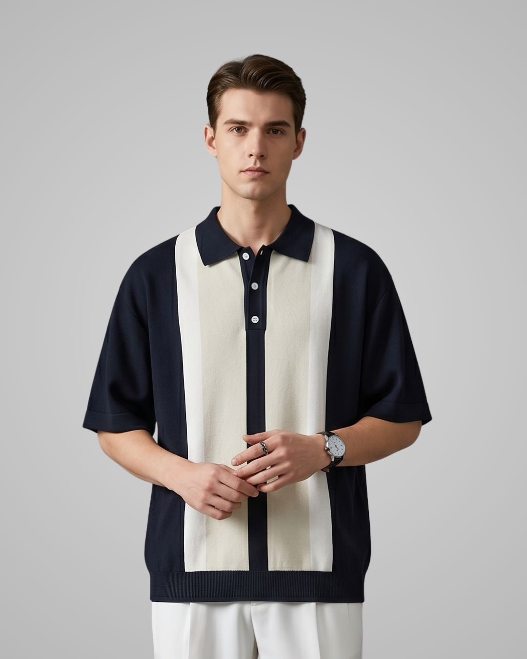 Man wearing a black and white striped polo shirt on a gray background