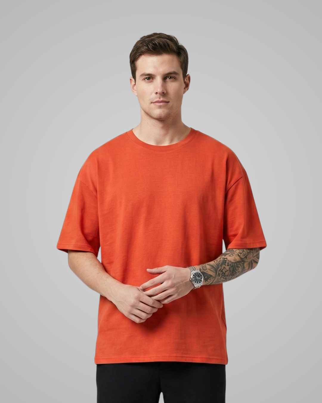 Man wearing an orange t-shirt against a gray background