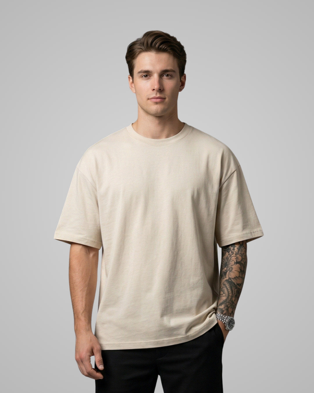 Man wearing a beige t-shirt against a gray background