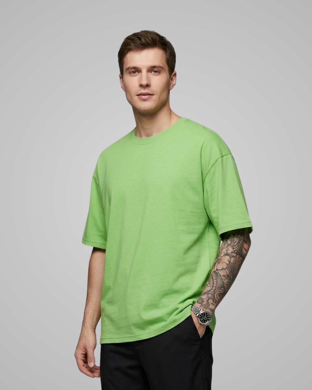 Man wearing a bright green t-shirt against a gray background