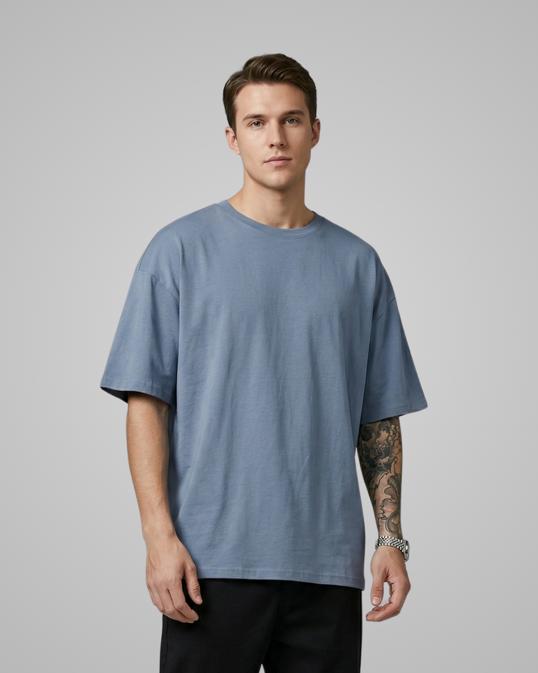 Man wearing a blue t-shirt against a gray background