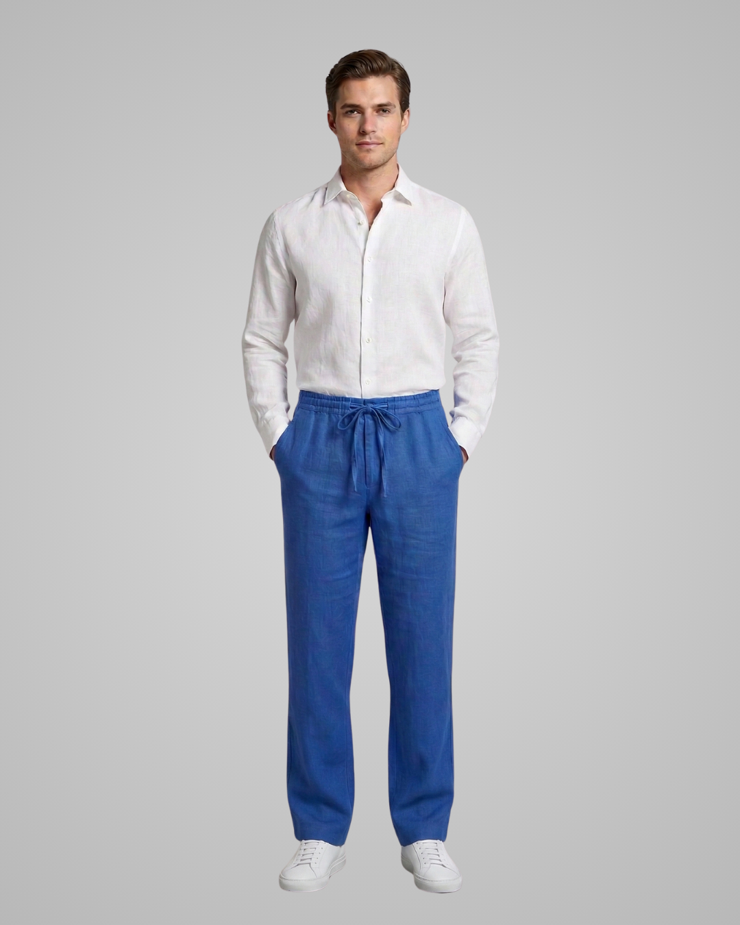 Man wearing a white shirt and blue pants on a gray background