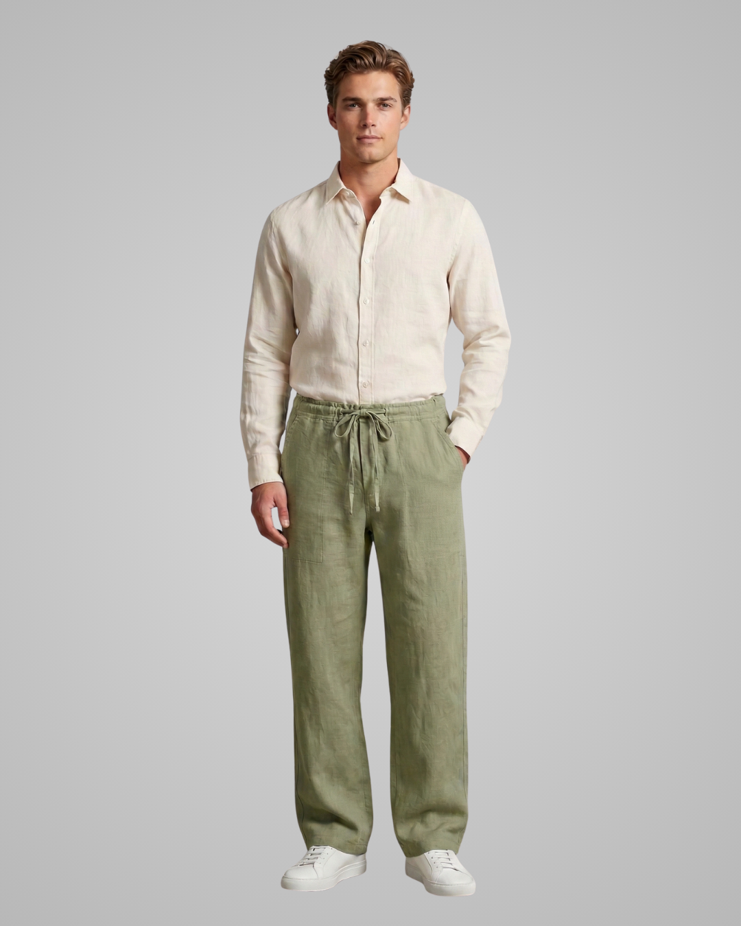 Man wearing a beige shirt and green pants on a gray background