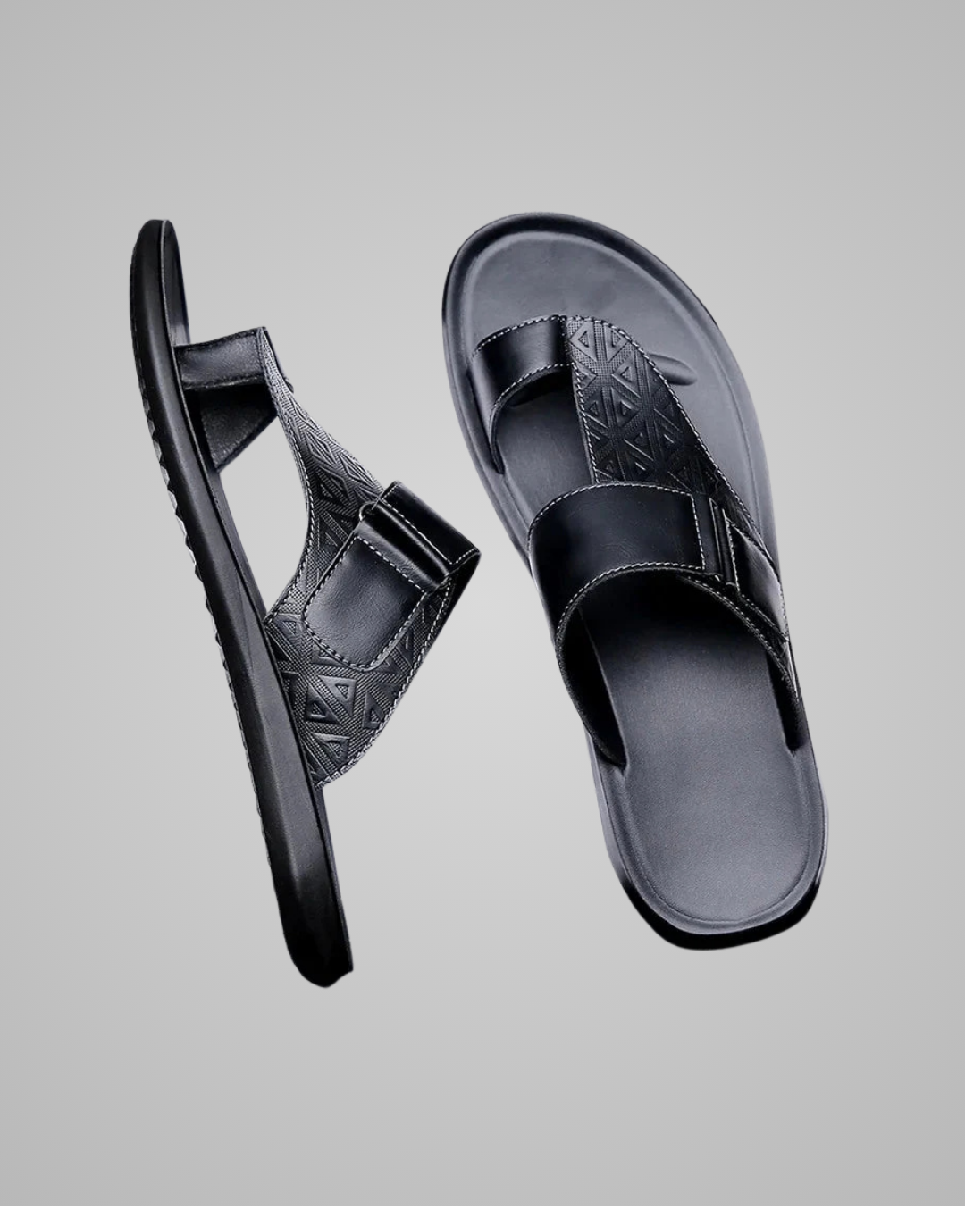 Black sandals with geometric patterns on a light gray background