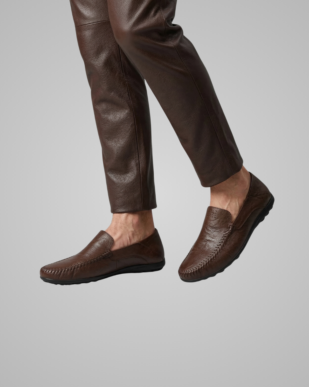 Brown leather shoes and pants on a gray background