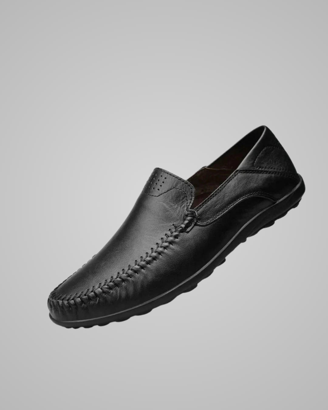 Black leather loafer shoe on a gray background