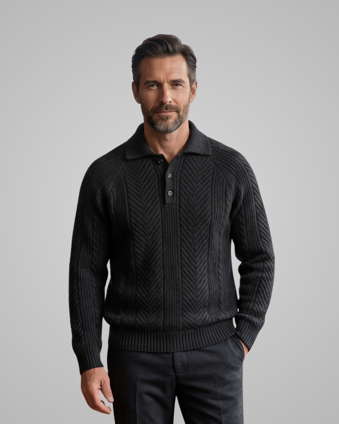 Man wearing a black patterned sweater against a gray background