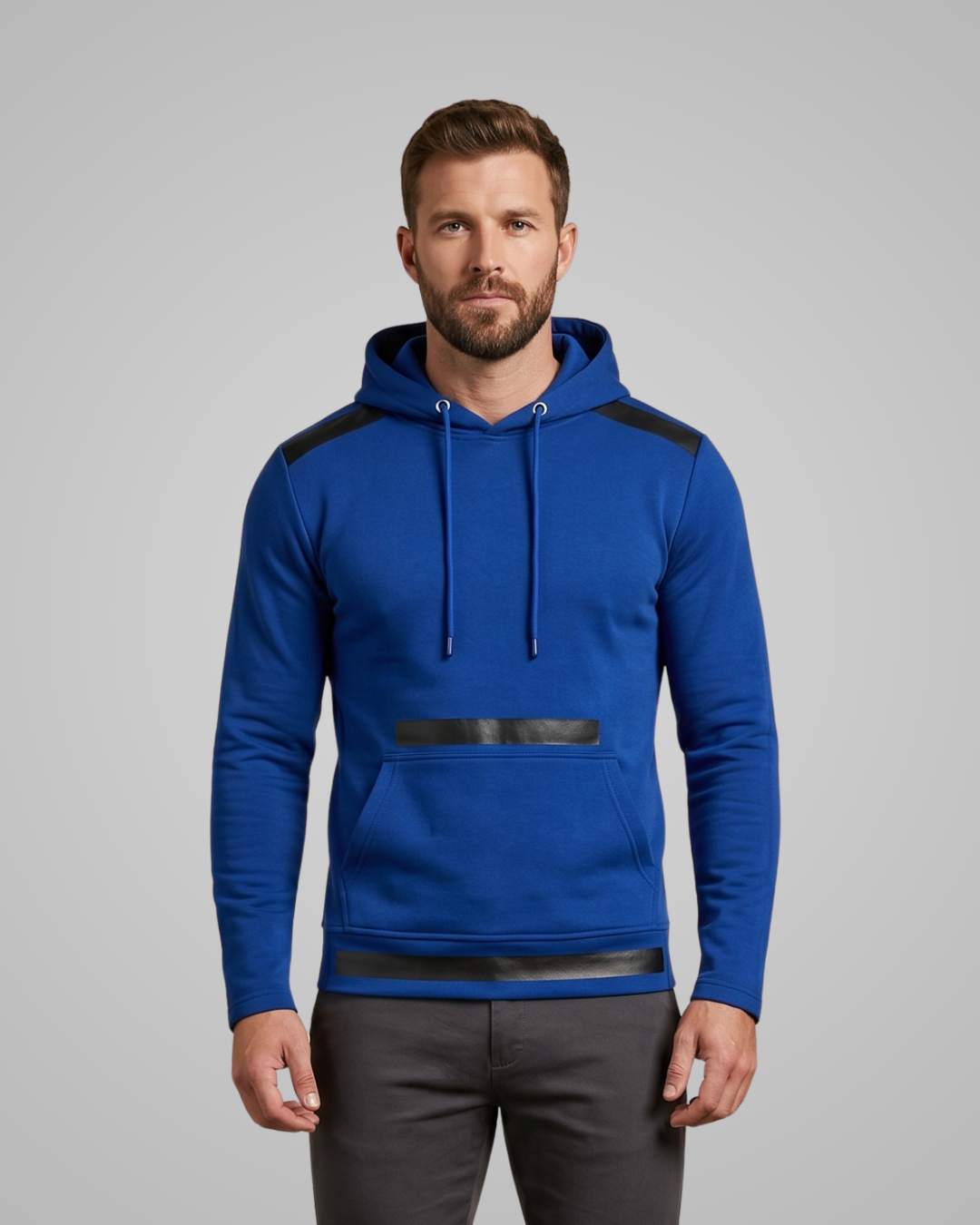 Man wearing a blue hoodie with black accents on a gray background