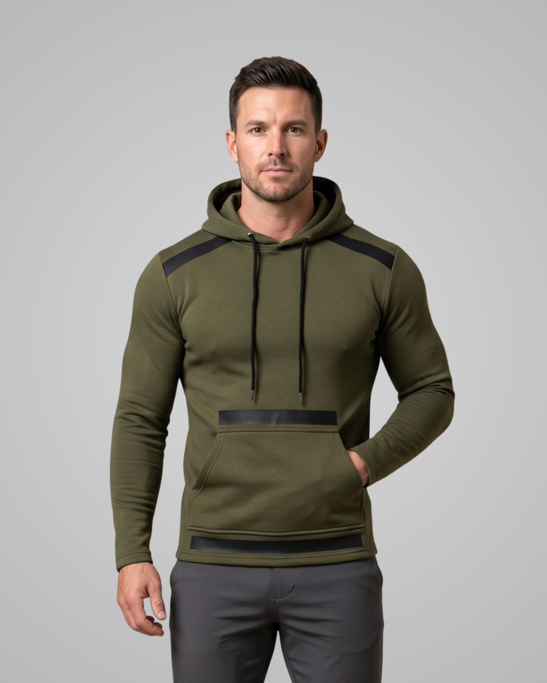 Man wearing an olive green hoodie with black accents on a gray background