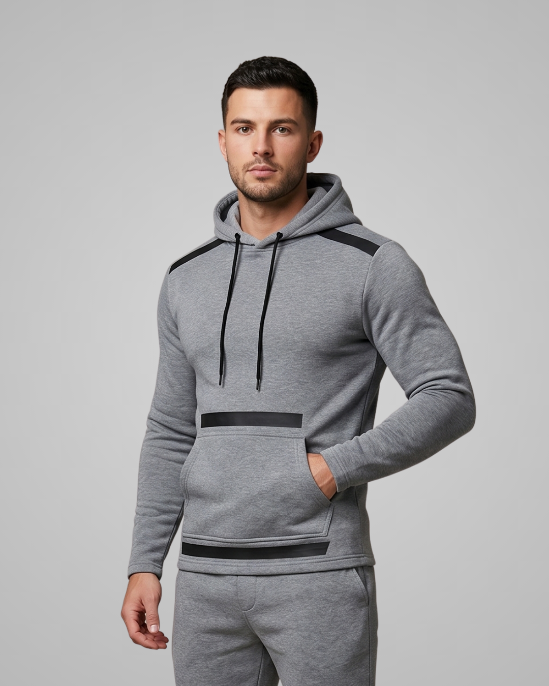 Man wearing a gray hoodie with black accents on a light gray background