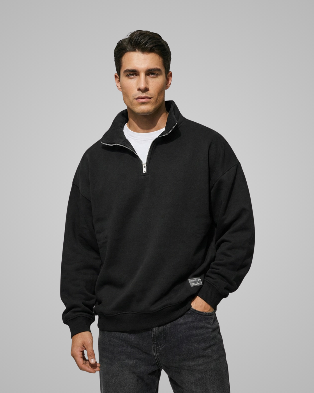 Man wearing a black quarter-zip sweatshirt on a gray background